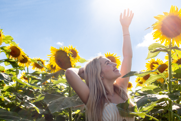 A girl surrounded with sunflowers and awesome sunshine